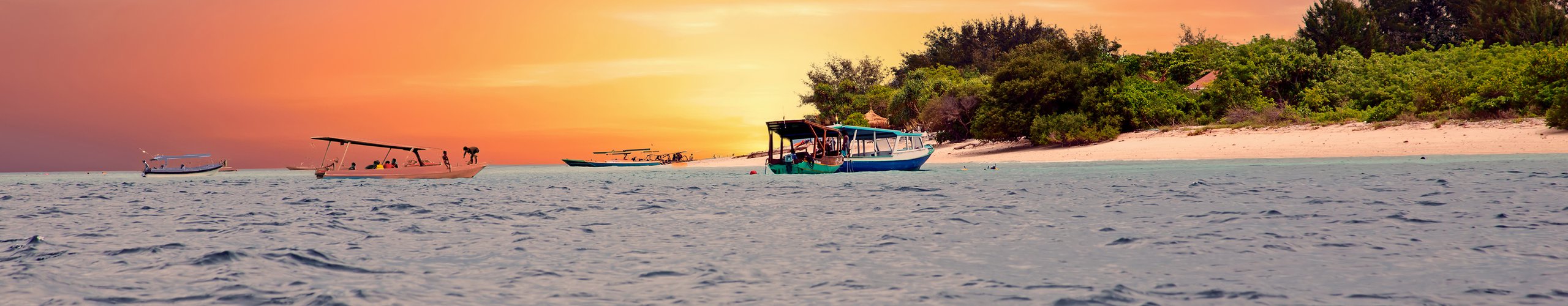 Sunset over moored boats off the Gili Islands, Lombok