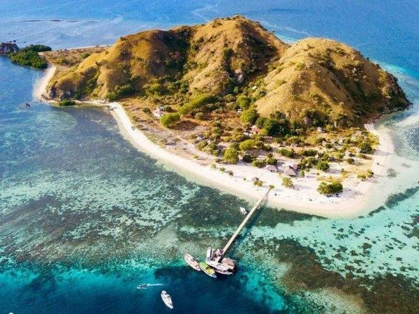 Aerial view of Kanawa Island ringed by turquoise reef, near Labuan Bajo