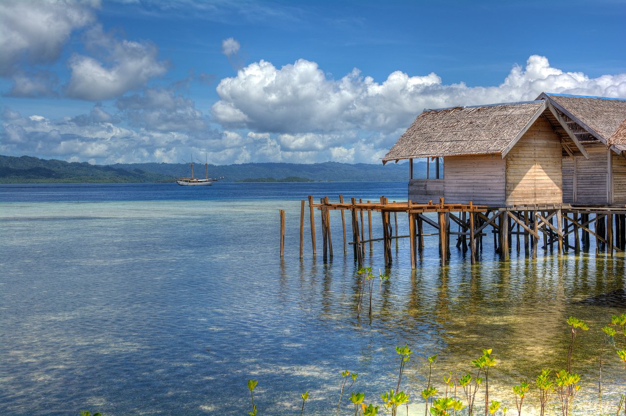 Stilted huts over clear water at Arborek, Raja Ampat